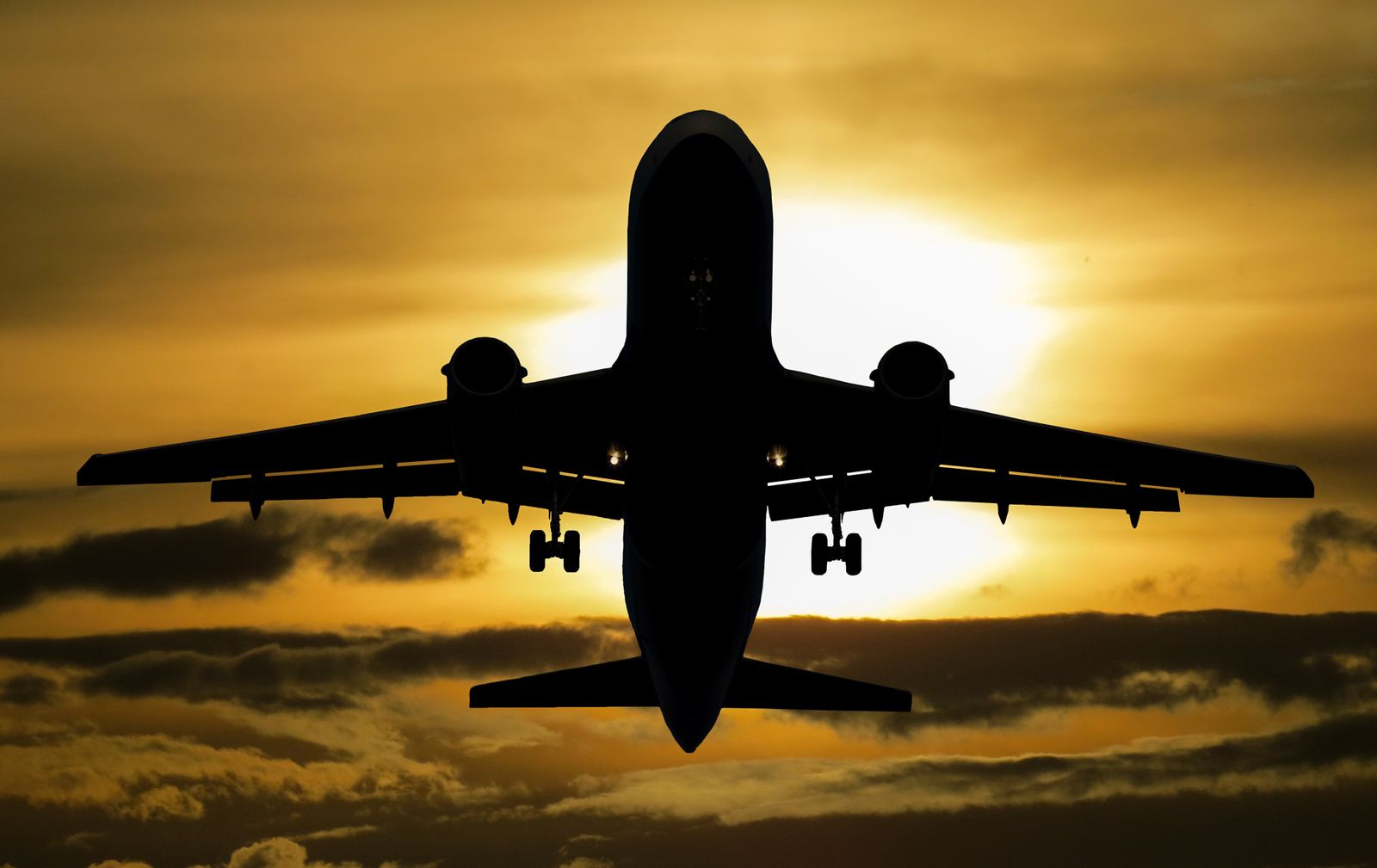 Airplane silhouette against a sunset sky